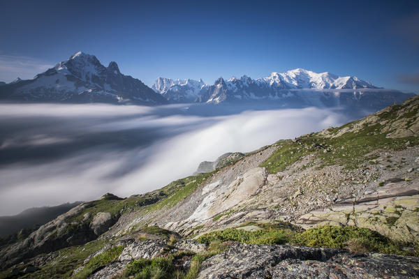 Low clouds and mist frame the snowy peaks of Mont Blanc and Aiguille Verte Chamonix Haute Savoie France Europe