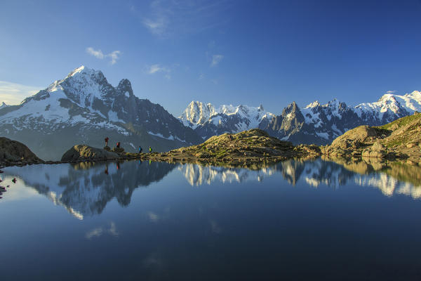 Photographers and hikers on the shore of Lac De Cheserys at dawn Haute Savoie France Europe