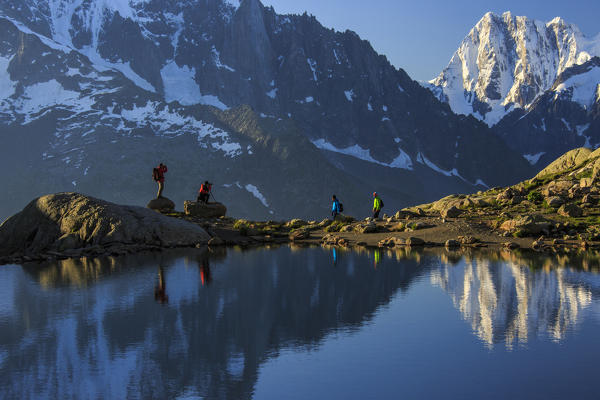 Photographers and hikers on the shore of Lac De Cheserys at dawn Haute Savoie France Europe