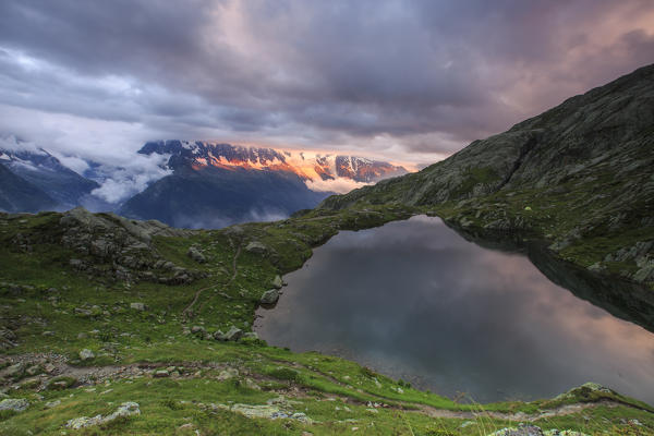 Clouds are tinged with purple at sunset at Lac de Cheserys  Chamonix Haute Savoie France Europe