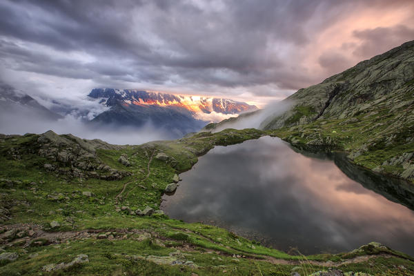 Clouds are tinged with purple at sunset at Lac de Cheserys  Chamonix Haute Savoie France Europe