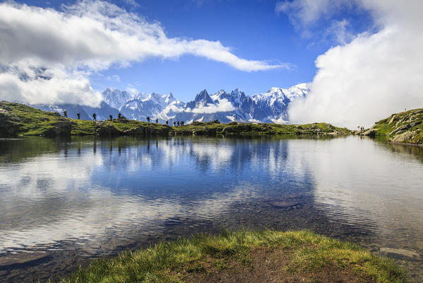 Low clouds and mist around Grandes Jorasses and Mount Blanc while hikers proceed on Lac De Cheserys Haute Savoie France Europe