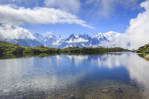 Low clouds and mist around Grandes Jorasses and Mount Blanc while hikers proceed on Lac De Cheserys Haute Savoie France Europe