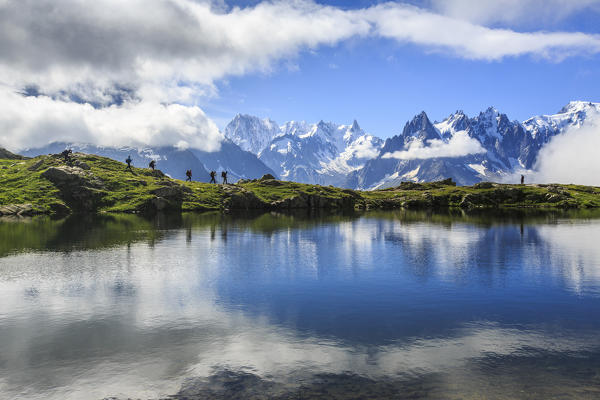 Low clouds and mist around Grandes Jorasses while hikers proceed on Lac De Cheserys Haute Savoie France Europe