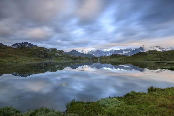 The snowy peaks are reflected in Fenetre Lakes at dawn Ferret Valley Saint Rhémy Grand St Bernard Aosta Valley Italy Europe