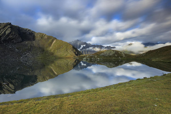 Green pastures and clouds frames The Fenetre Lakes Ferret Valley Saint Rhémy Grand St Bernard Aosta Valley Italy Europe