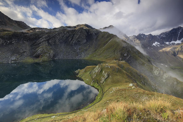 Mist and clouds on high peaks frame the Fenetre Lakes Ferret Valley Saint Rhémy Grand St Bernard Aosta Valley Italy Europe