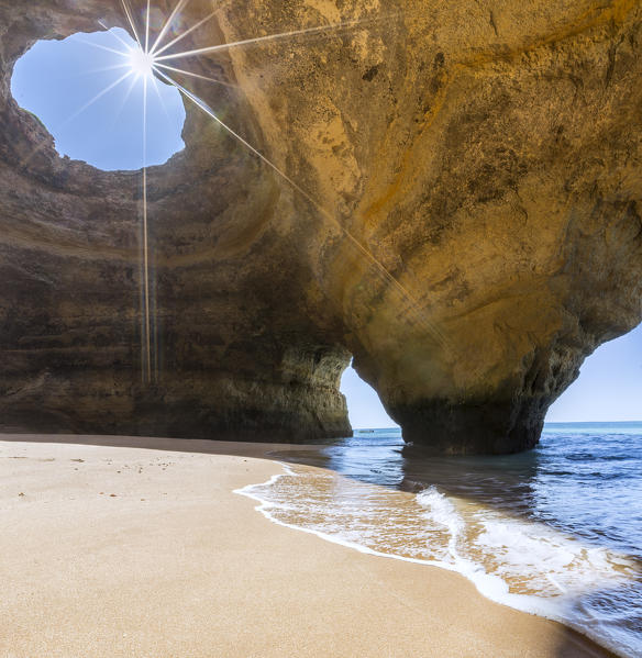 The sun shines through the natural rocky windows inside the caves of Benagil Faro District Algarve Portugal Europe