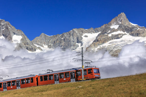 The Bahn train on its route with high peaks and mountain range in the background Gornergrat Canton of Valais Switzerland Europe