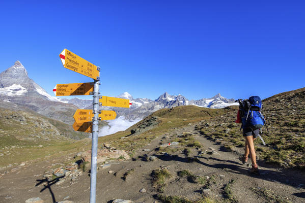 Hiker proceeds towards the Matterhorn in a clear summer day Gornergrat Canton of Valais Switzerland Europe