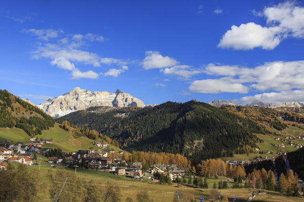 The colorful woods frame the village and the high peaks in autumn Gardena Valley South Tyrol Trentino Alto Adige Italy Europe