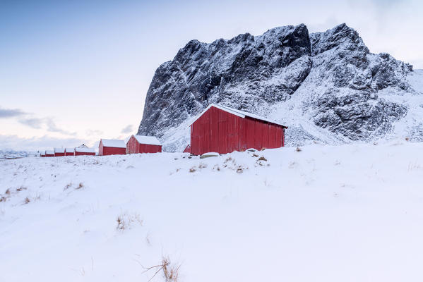 Snowy peaks surround the typical fishermen houses called Rorbu in winter Eggum Vestvagøy Island Lofoten Islands Norway Europe