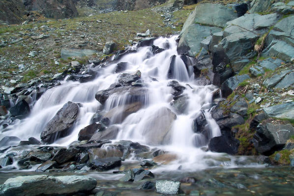 The stream Entovasco jumping from one stone to another creates a foaming waterfall. Valmalenco. Valtellina. Lombardy. Italy Europe