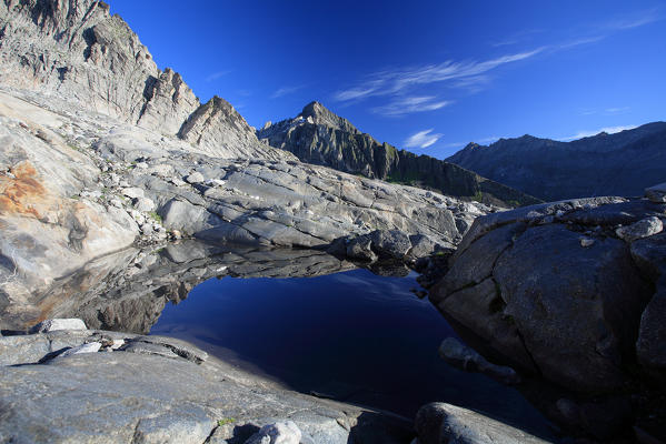 The small lake of Vazzeda hidden among the rocks at the foot of the glacier Vazzeda. Valmalenco. Valtellina Lombardy. Italy Europe