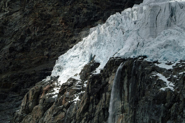 A waterfall collects the meltwater from the Fellaria glacier. Valmalenco. Valtellina Lombardy. Italy Europe