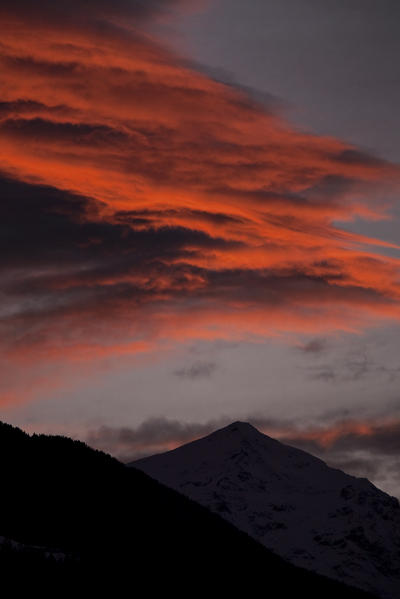 Clouds color the sky at sunset above Mount Legnone lower Valtellina. Morbegno. Lombardy. Italy Europe