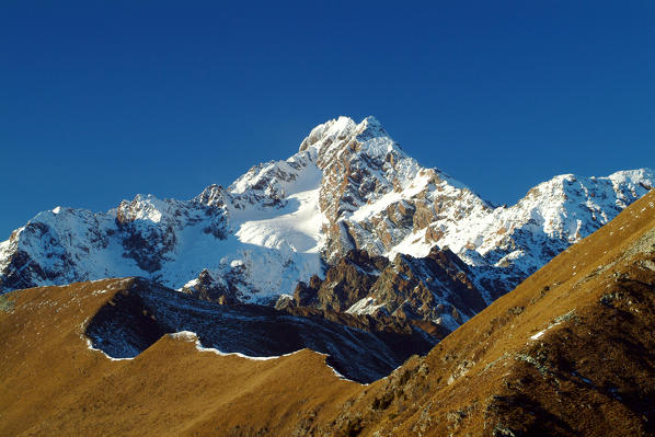 The south slope of Mount Disgrazia and in the foreground the ridge of Bianco Peak after an autumn snowfall. Mount Rolla Valtellina Lombardy Italy. Europe