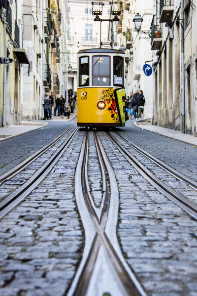 The characteristic yellow tram proceed towards Bairro Alto a central district of the old city of Lisbon Portugal Europe