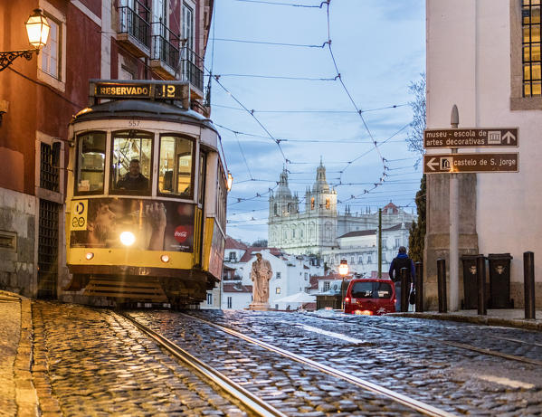 Romantic atmosphere in the old streets of  Alfama with the castle in the background and tram number 28 Lisbon Portugal Europe