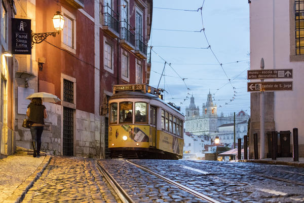 Romantic atmosphere in the old streets of  Alfama with the castle in the background and tram number 28 Lisbon Portugal Europe