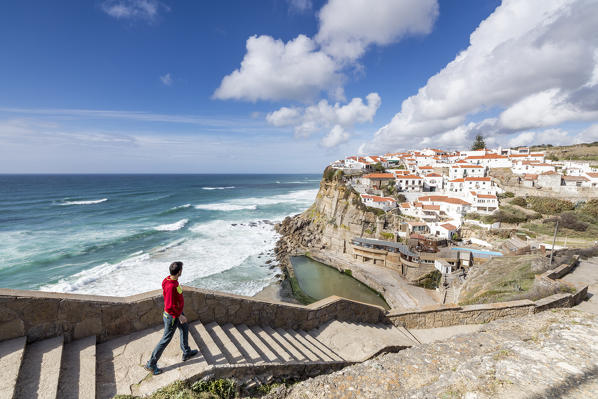 Tourist admires the perched village of Azenhas do Mar surrounded by the blue water of the Atlantic Ocean Sintra Portugal Europe