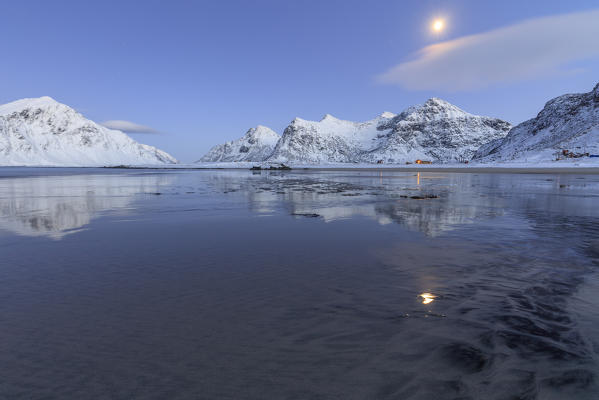 Black sand and full moon as surreal scenery at Skagsanden beach Flakstad Nordland county Lofoten Islands Norway Europe