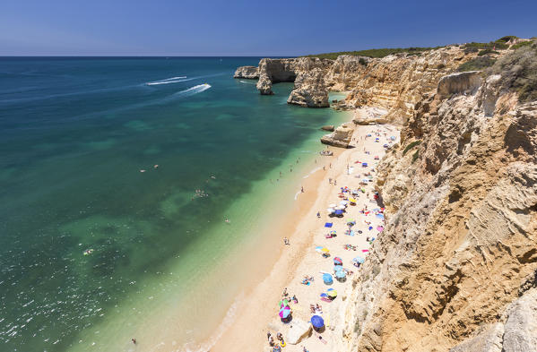 Tourists on sandy beach Praia da Marinha surrounded by turquoise ocean Caramujeira Lagoa Municipality Algarve Portugal Europe