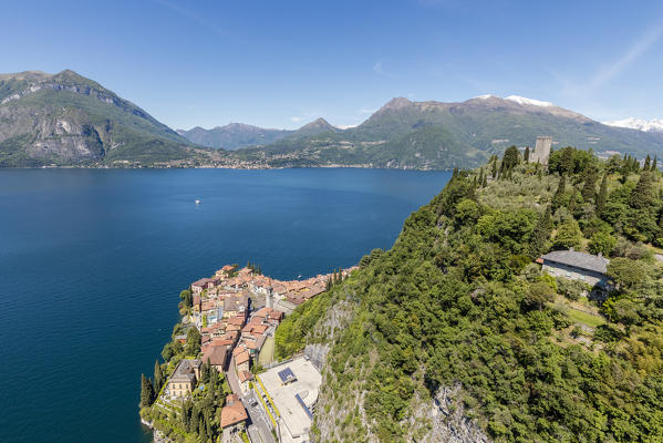 Aerial view of the green hill and castle overlooking Varenna surrounded by Lake Como Lecco Province Lombardy Italy Europe