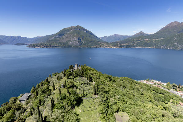 Aerial view of the green hill and castle overlooking Varenna surrounded by Lake Como Lecco Province Lombardy Italy Europe