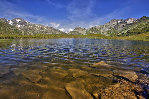 Choppy waters by summer wind on the little lake of Andossi  that blows towards the Tambo Peak and Suretta Peak. Madesimo. Spluga Valley. Valchiavenna. Lombardy. Italy. Europe