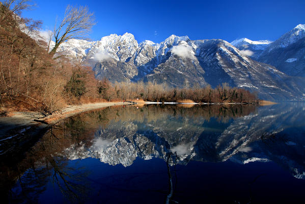 Rhaetian Alps of group Masino-Bregaglia are reflected in the still waters of Lake Novate Mezzola. Valchiavenna. Valtellina. Vallespluga. Lombardy. Italy. Europe. 