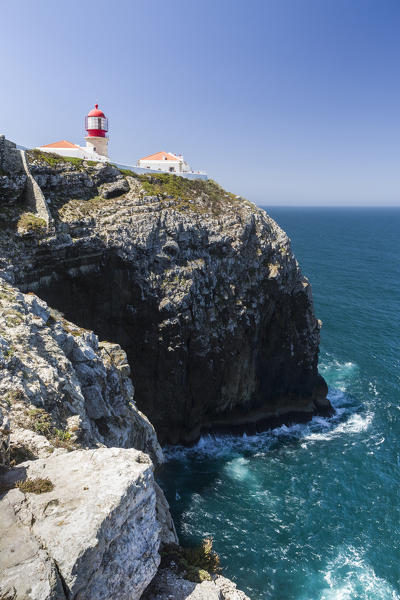 The cliffs and lighthouse overlooks the blue Atlantic ocean at Cabo De San Vicente Sagres Algarve Portugal Europe