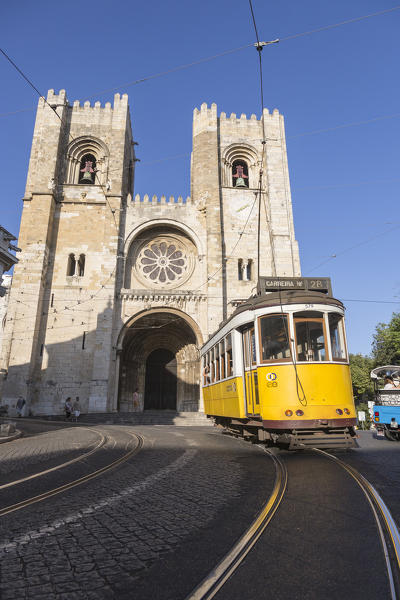 The yellow tram number 28 close to the ancient cathedral of Alfama district Lisbon Portugal Europe