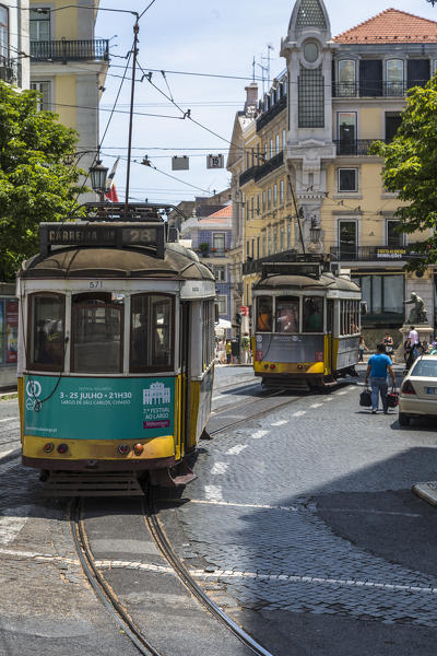 A typical tram takes tourists to discover the old city of Lisbon with its architecture and colorful houses Portugal Europe