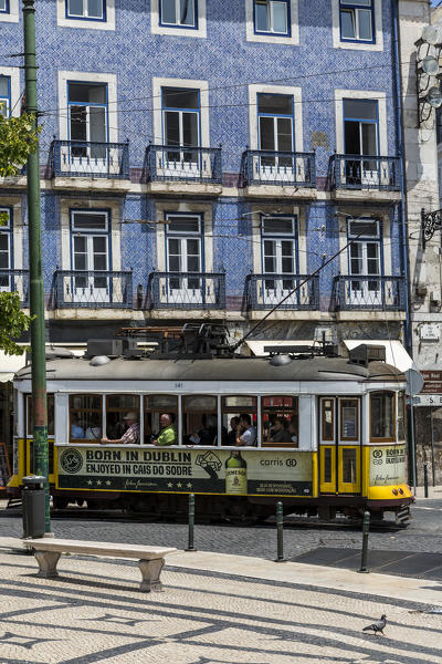 A typical tram takes tourists to discover the old city of Lisbon with its architecture and colorful houses Portugal Europe
