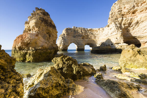 Sunrise on the cliffs and turquoise water of the ocean Praia da Marinha Caramujeira Lagoa Municipality Algarve Portugal Europe