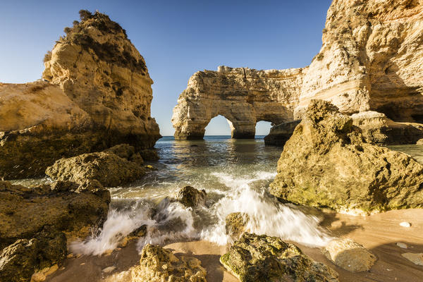 Sunrise on the cliffs and turquoise water of the ocean Praia da Marinha Caramujeira Lagoa Municipality Algarve Portugal Europe