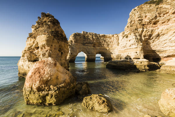 Sunrise on the cliffs and turquoise water of the ocean Praia da Marinha Caramujeira Lagoa Municipality Algarve Portugal Europe