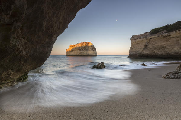 A sea cave frames the beach of Praia De Albandeira at dawn Carvoeiro Caramujeira Lagoa Municipality Algarve Portugal Europe