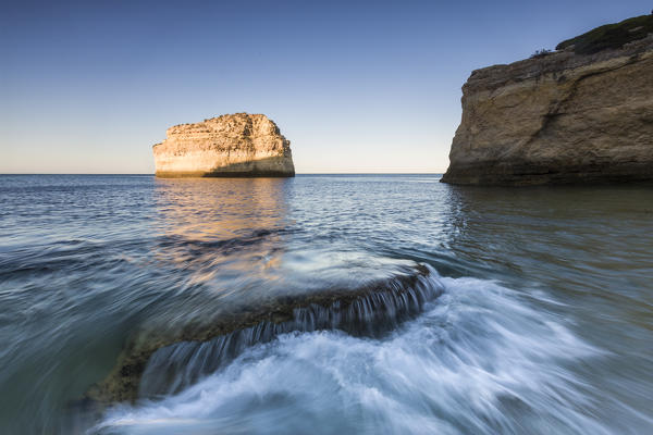 Ocean waves crashing on rocks at sunrise Praia De Albandeira  Carvoeiro Caramujeira Lagoa Municipality Algarve Portugal Europe