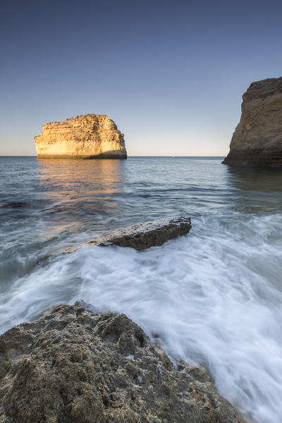 Ocean waves crashing on rocks at sunrise Praia De Albandeira  Carvoeiro Caramujeira Lagoa Municipality Algarve Portugal Europe