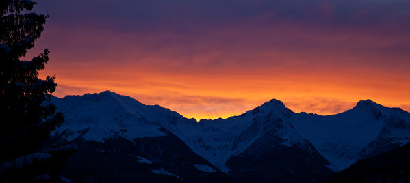 The sunrise lights up the colors of the sky above Bitto Valley of Albaredo. Rasura. Valgerola. Alps Orobie. Valtellina. Lombardy. Italy. Europe