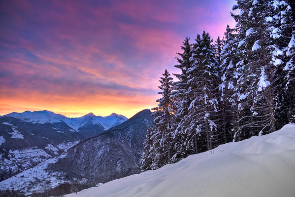 The sunrise lights up the colors of the sky above Bitto Valley of Albaredo. Rasura. Valgerola. Alps Orobie. Valtellina. Lombardy. Italy. Europe