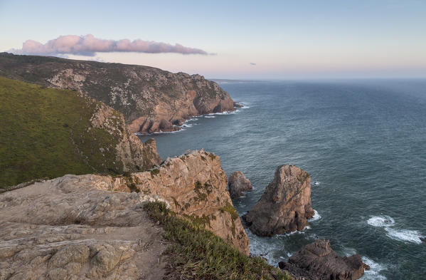Ocean waves crashing on the cliffs of the Cabo da Roca cape at sunset Sintra Portugal Europe