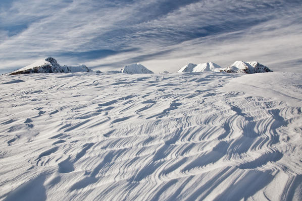 Sinuous curves in the snow shaped by the wind after a storm. Olano Alp. Rasura. Valgerola. Alps Orobie. Valtellina. Lombardy. Italy. Europe