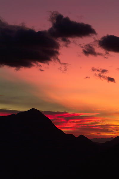 The bright colours of a sunset over Mount Legnone, Orobie Alps, Valtellina, Lombardy Italy Europe