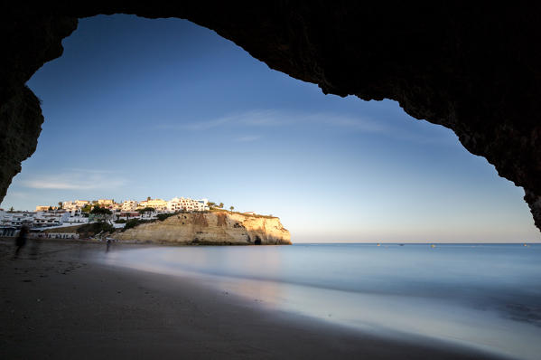 View from a sea cave of the fishing village of Carvoeiro perched on a reef at sunset Algarve Lagoa Faro District Portugal Europe