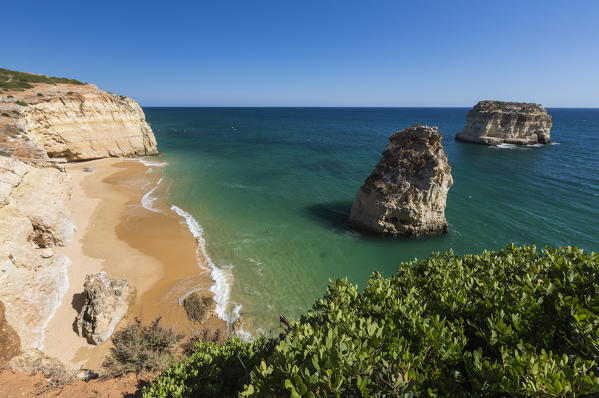 The ocean waves crashing on the sandy beach and the cliffs of Praia do Torrado Algarve Lagoa Faro District Portugal Europe