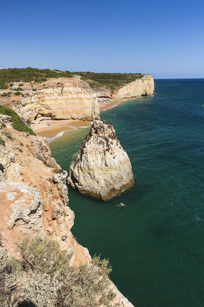 The turquoise waters of the ocean frames the sandy beach around Praia do Torrado Algarve Lagoa Faro District Portugal Europe
