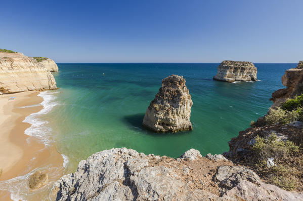 The ocean waves crashing on the sandy beach and the cliffs of Praia do Torrado  Algarve Lagoa Faro District Portugal Europe